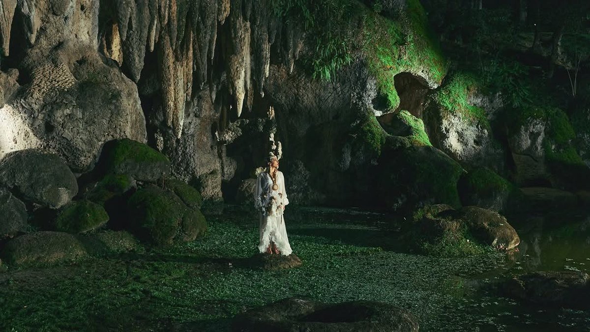 Anitta deitada entre flores: o EQUILIBRIVM mistura religiosidade e natureza.
