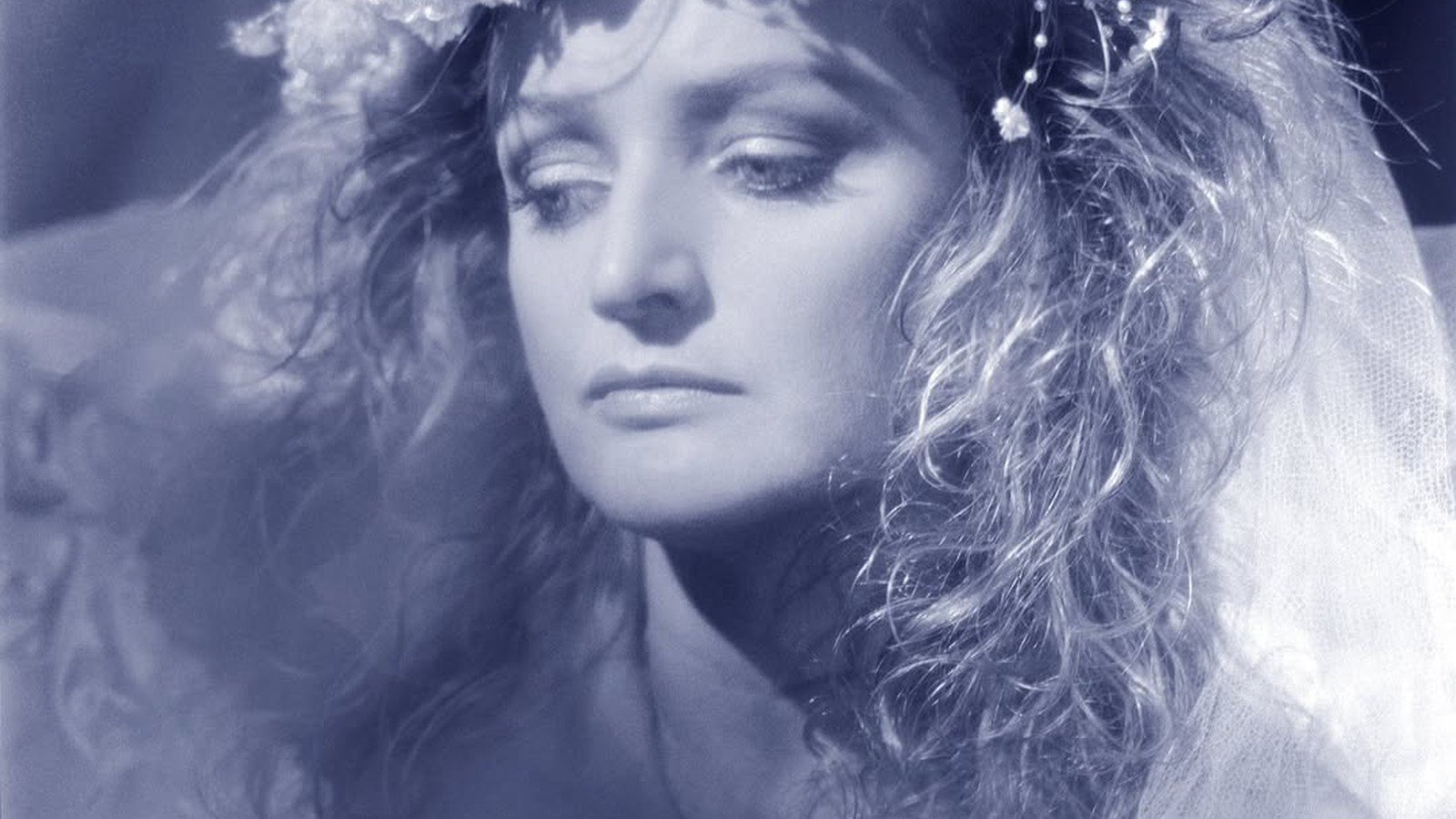 Bonnie Tyler em foto azulada com coroa de flores, arte do single Band of Gold
