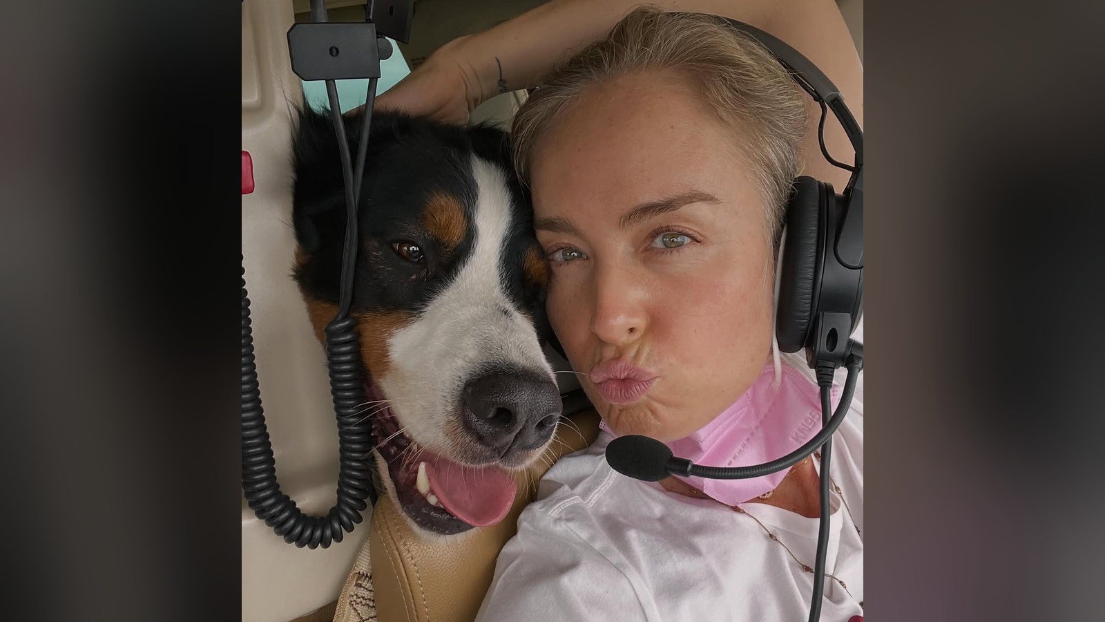Angelica de fone de ouvido e microfone dentro de um helicoptero, com o cao Obama ao lado, tambem de fone