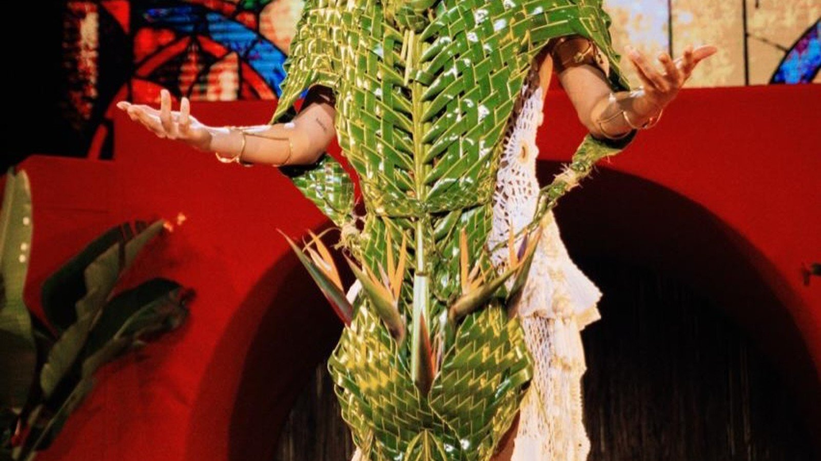 Anitta de vestido verde com bracos abertos no palco da turne EQUILIBRIVM