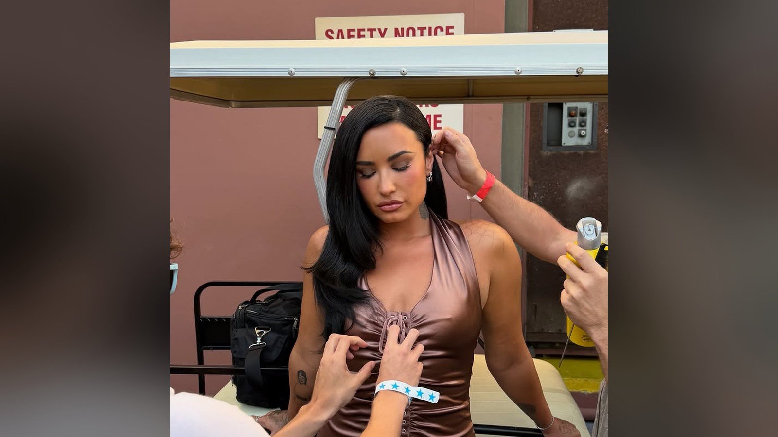 Demi Lovato sendo maquiada e penteada por uma equipe durante as gravacoes