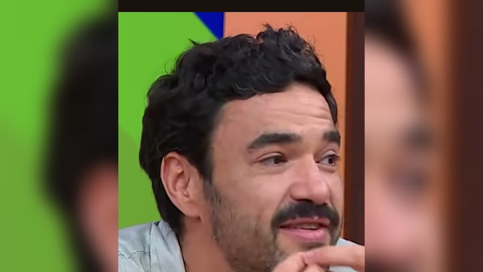 Caio Blat, de camisa clara, fala e gesticula durante entrevista em estúdio de televisão