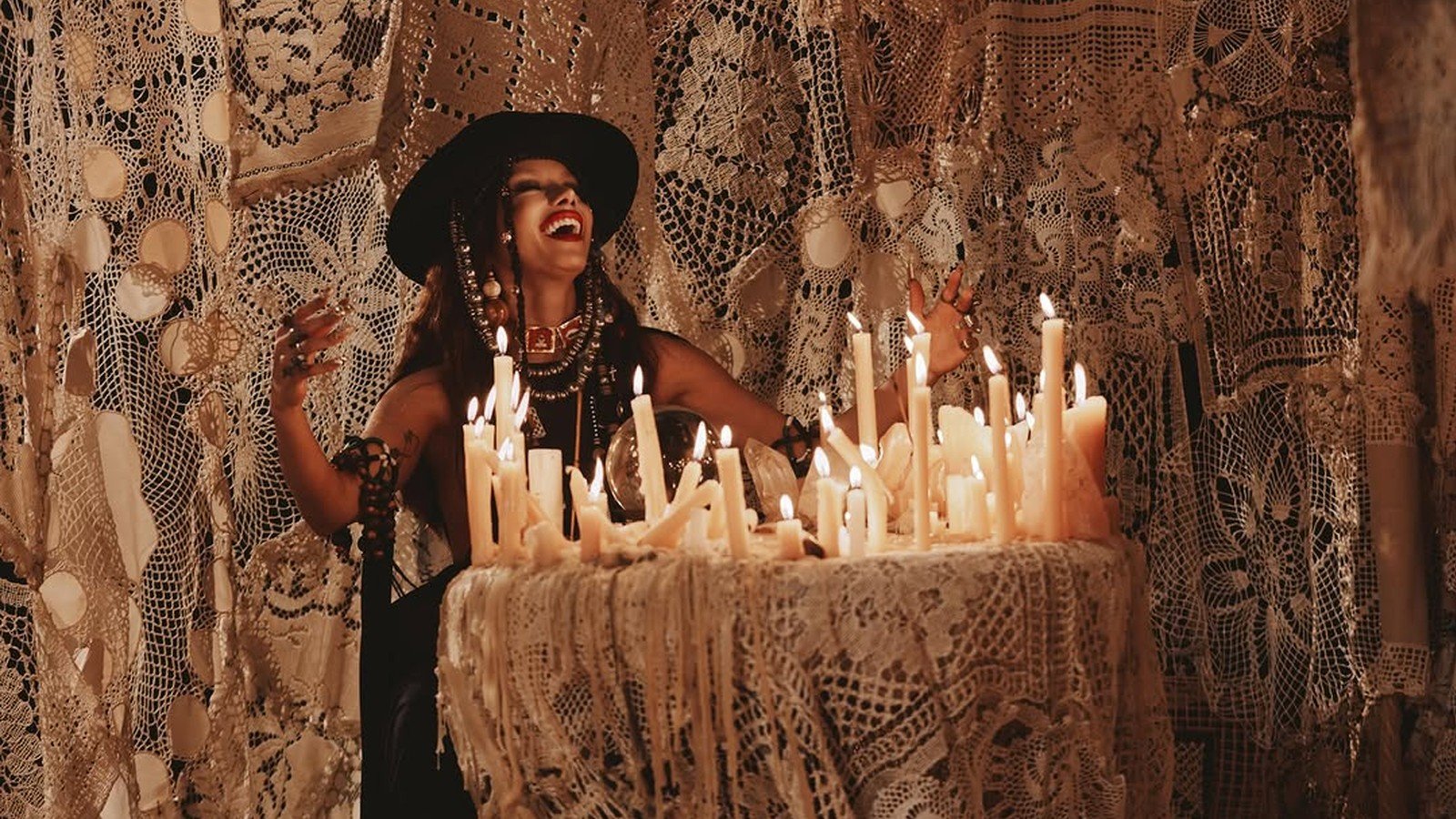 Anitta sentada diante de dezenas de velas acesas em imagem do projeto EQUILIBRIVM