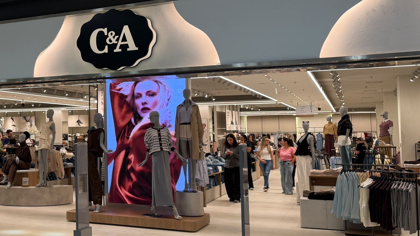 Interior da loja C&A do Butanta Shopping, com manequins, telao e clientes circulando