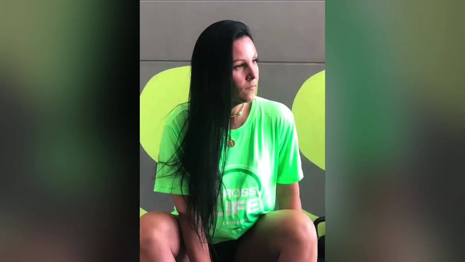 Juliana Ungaretti, de camiseta verde, sentada em um banco de academia em foto publicada pela irmã