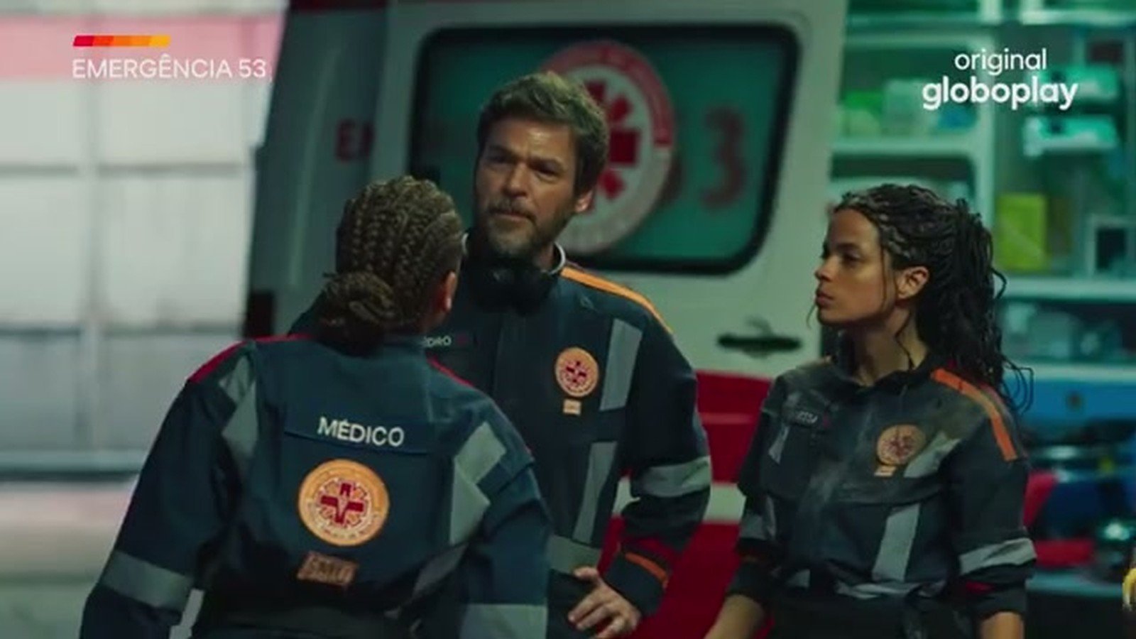 Equipe de socorristas de Emergencia 53 conversa ao lado da ambulancia aberta, um deles com o colete escrito medico