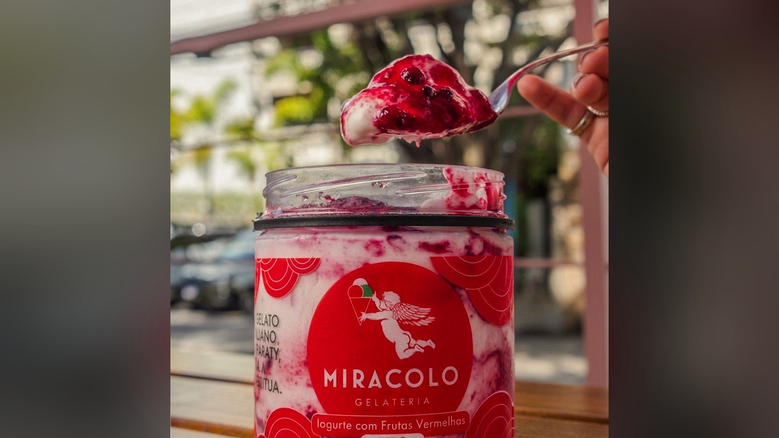 Pote da Miracolo de iogurte com frutas vermelhas versao zero, com uma colher cheia acima