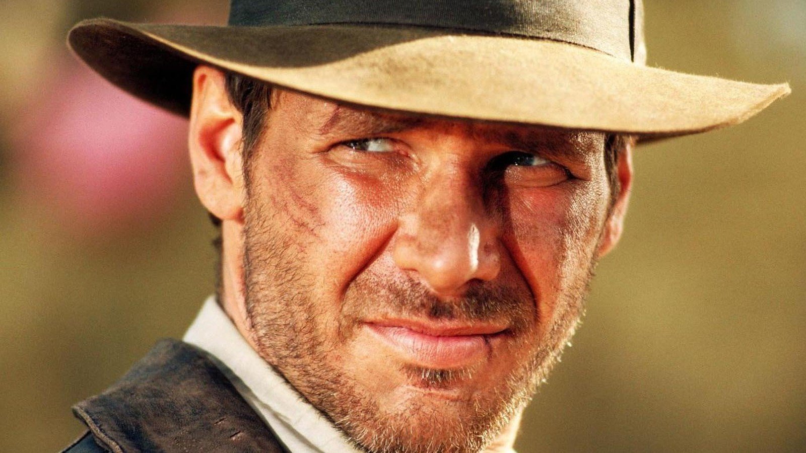 Harrison Ford caracterizado como Indiana Jones, de chapéu, em close