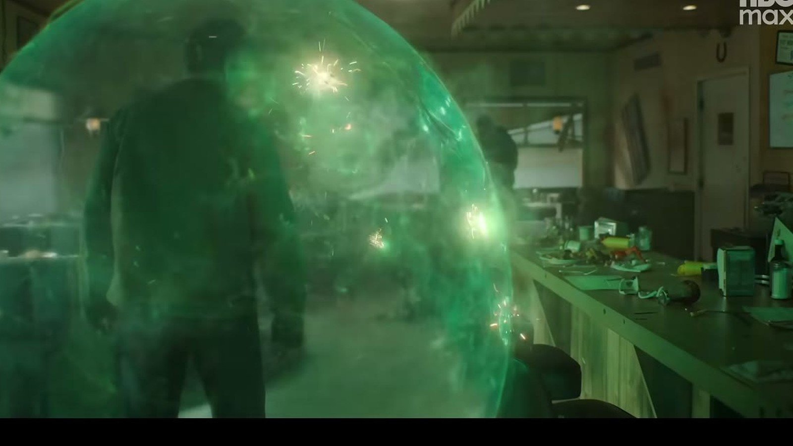 Bolha de energia verde envolve um personagem dentro de uma lanchonete em cena da serie