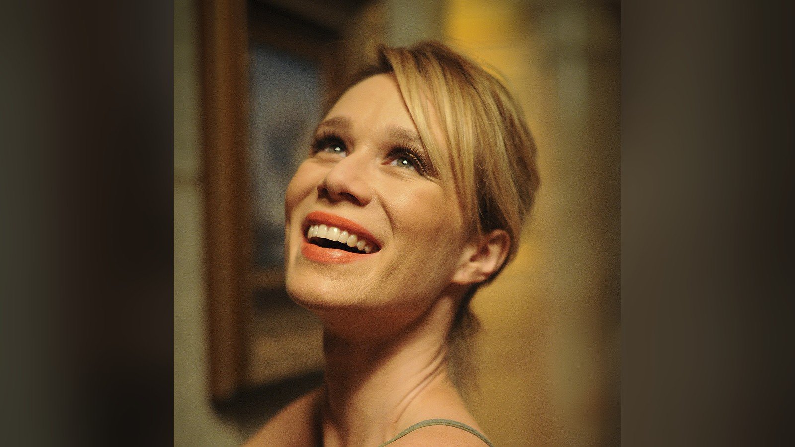 Mariana Ximenes em foto de 2012, cabelo loiro, sorrindo e olhando para cima