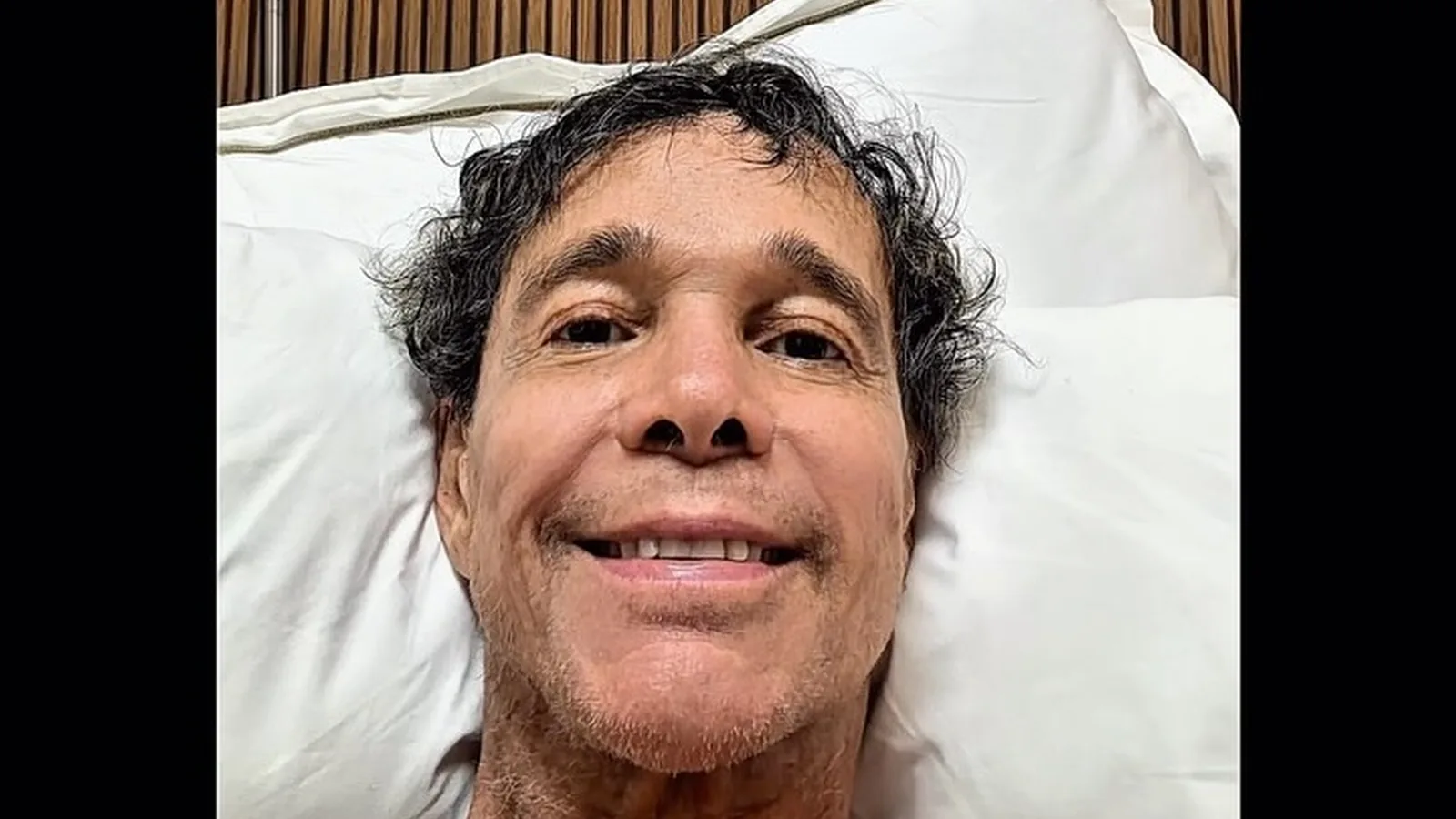 Netinho sorri deitado em um leito hospitalar, em foto publicada por ele mesmo
