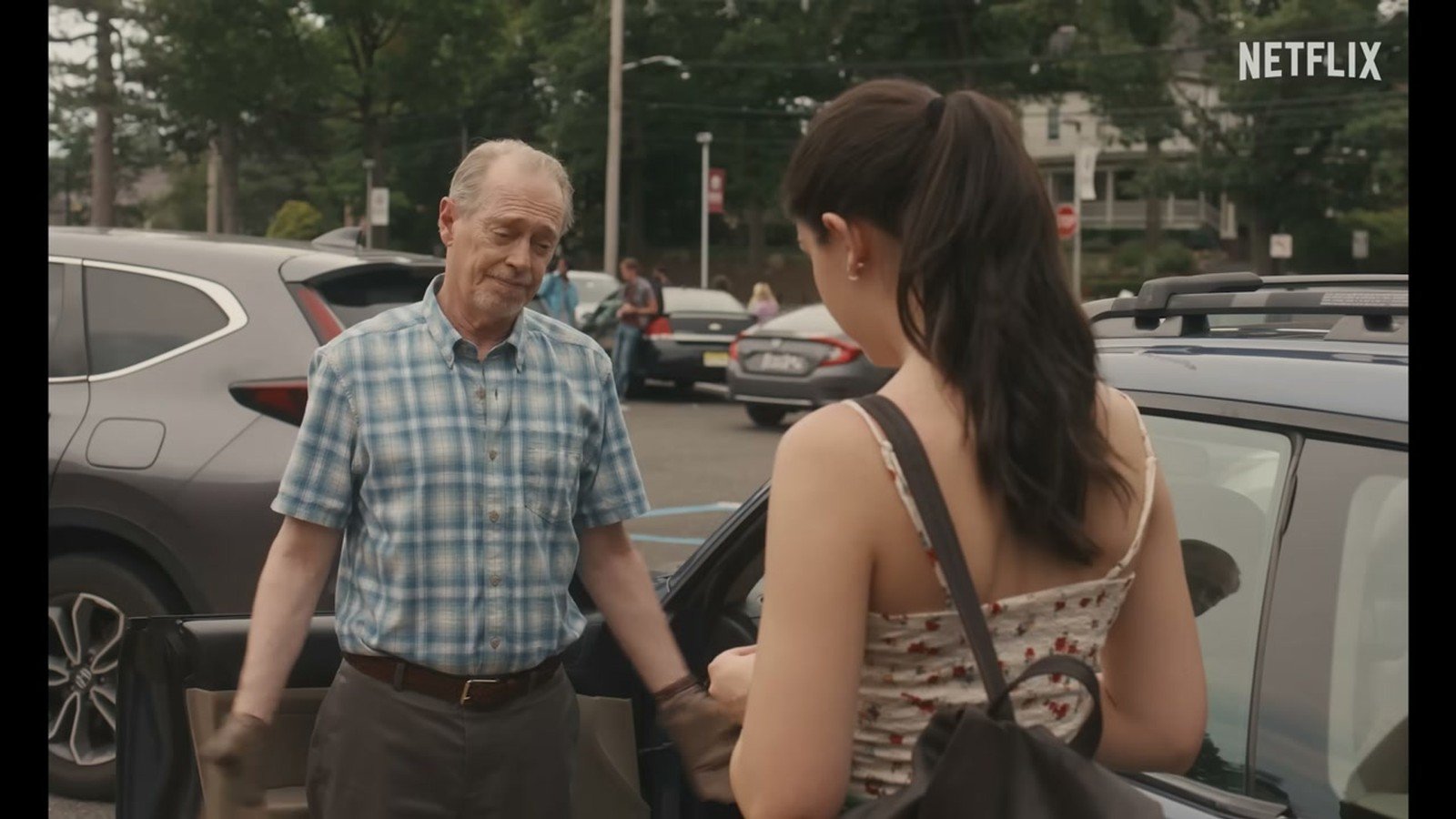 Steve Buscemi de camisa xadrez conversa com Sophie no estacionamento em cena do filme