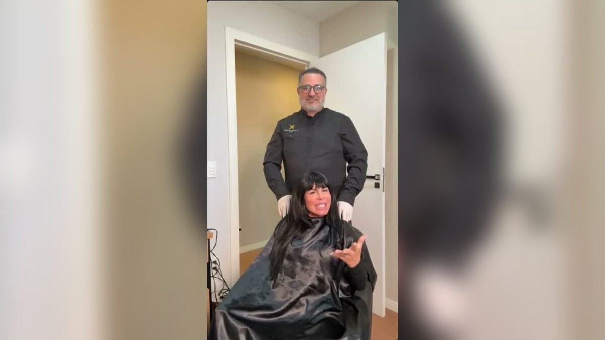 Gretchen sentada em cadeira de procedimento, com o médico em pé atrás dela