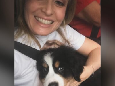 Angelica sorrindo em selfie com o filhote Obama, boiadeiro bernes preto branco e caramelo, no colo