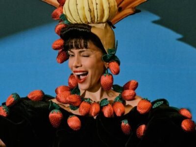 Anitta com turbante de frutas e colar de morangos, em figurino da turnê EQUILIBRIVM