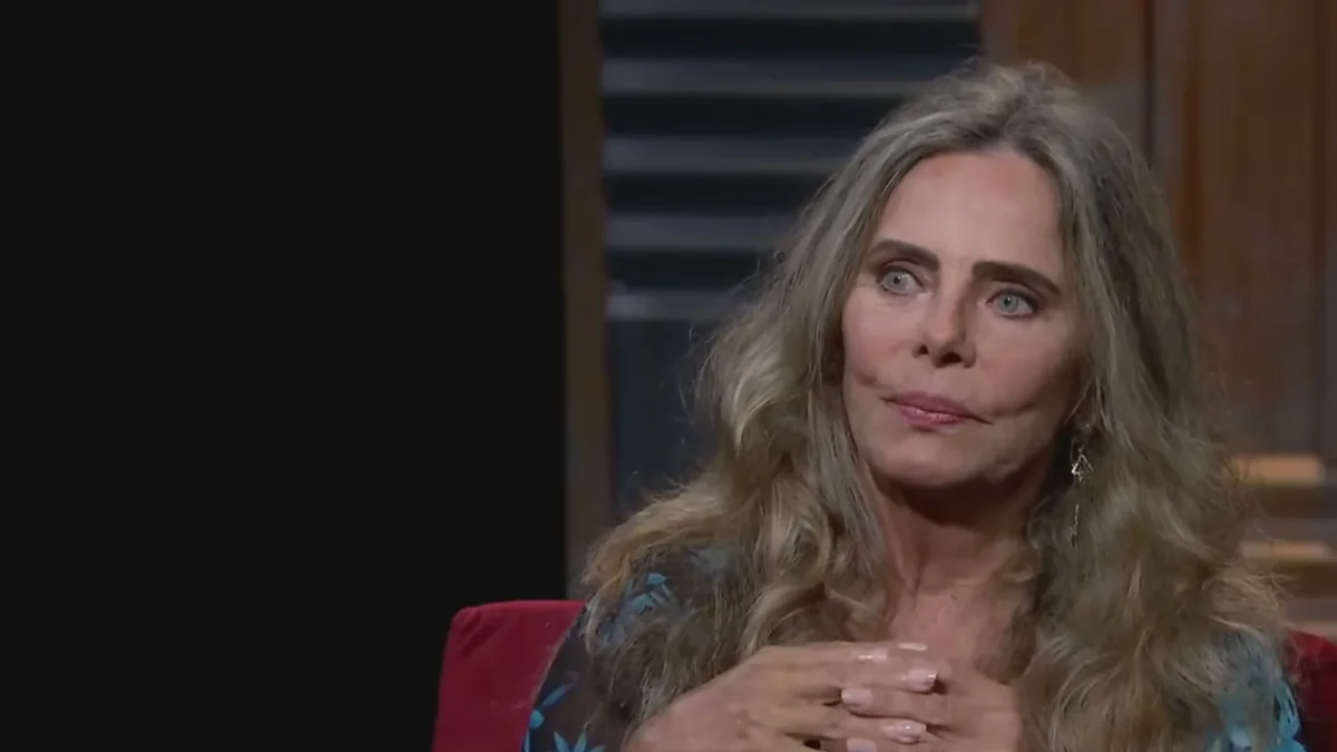 Bruna Lombardi de blusa azul estampada, cabelo solto, durante entrevista em estúdio de televisão