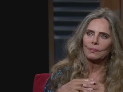 Bruna Lombardi de blusa azul estampada, cabelo solto, durante entrevista em estúdio de televisão