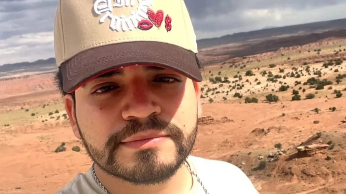 César Gastélum de boné bege, barba escura, em selfie ao ar livre