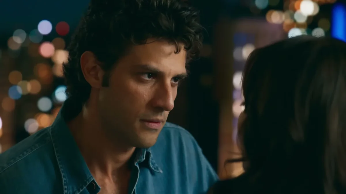 Chay Suede em close como Pedro, de camisa jeans, em cena noturna de Quem Ama Cuida