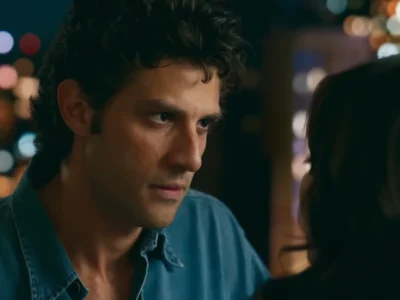 Chay Suede em close como Pedro, de camisa jeans, em cena noturna de Quem Ama Cuida