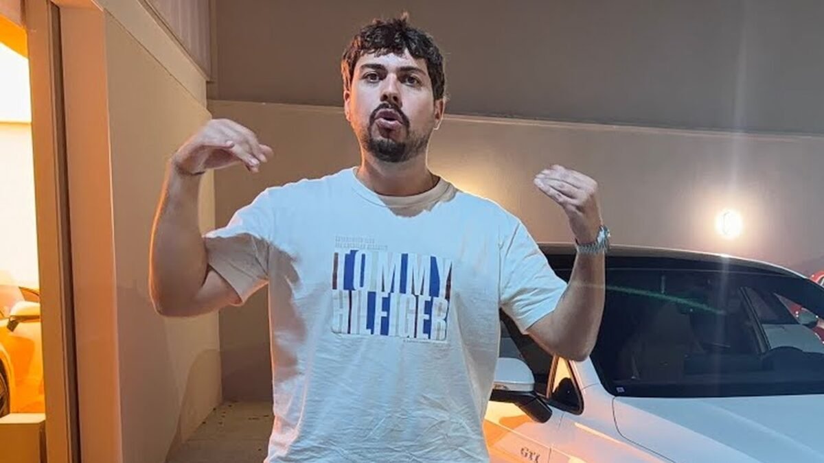 Eduardo Razuk ao lado de um dos carros rifados, no galpão que aparece nos vídeos do canal dele. Reprodução/YouTube Backstage