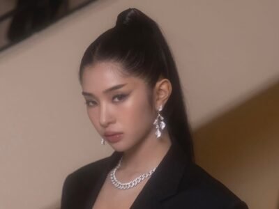 Sophia Laforteza de blazer preto e colar de prata, cabelo preso, olhando para a câmera
