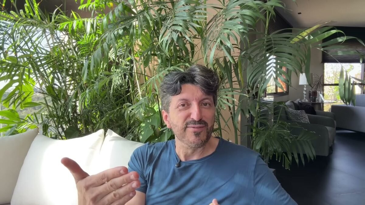 Lito Sousa de camiseta azul, olhando para a camera, em video gravado em casa