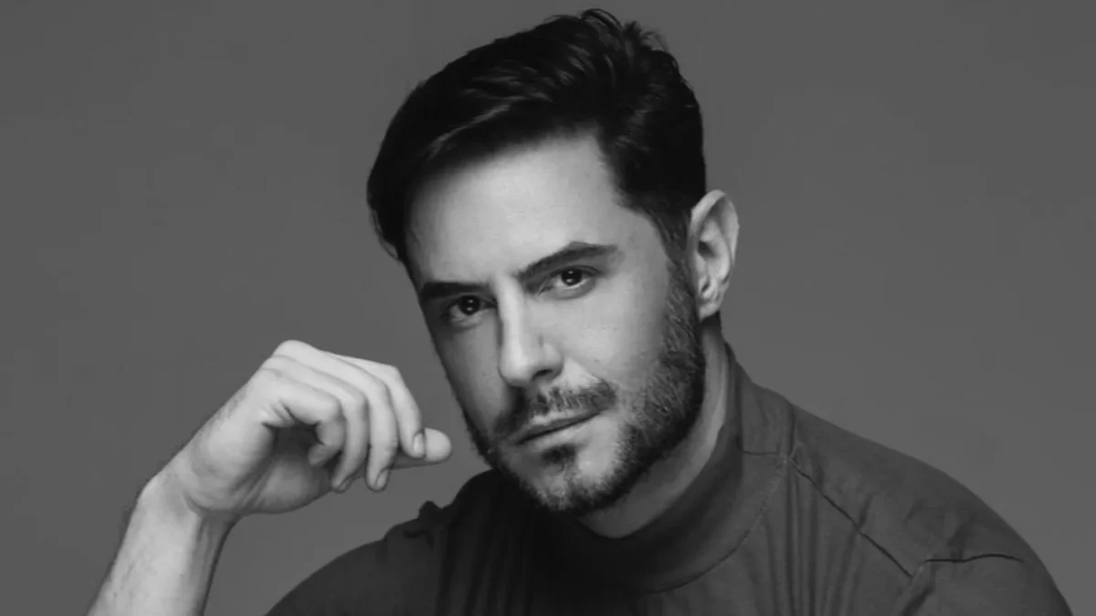 Retrato em preto e branco de Ricardo Tozzi, de barba curta, apoiando o rosto na mão