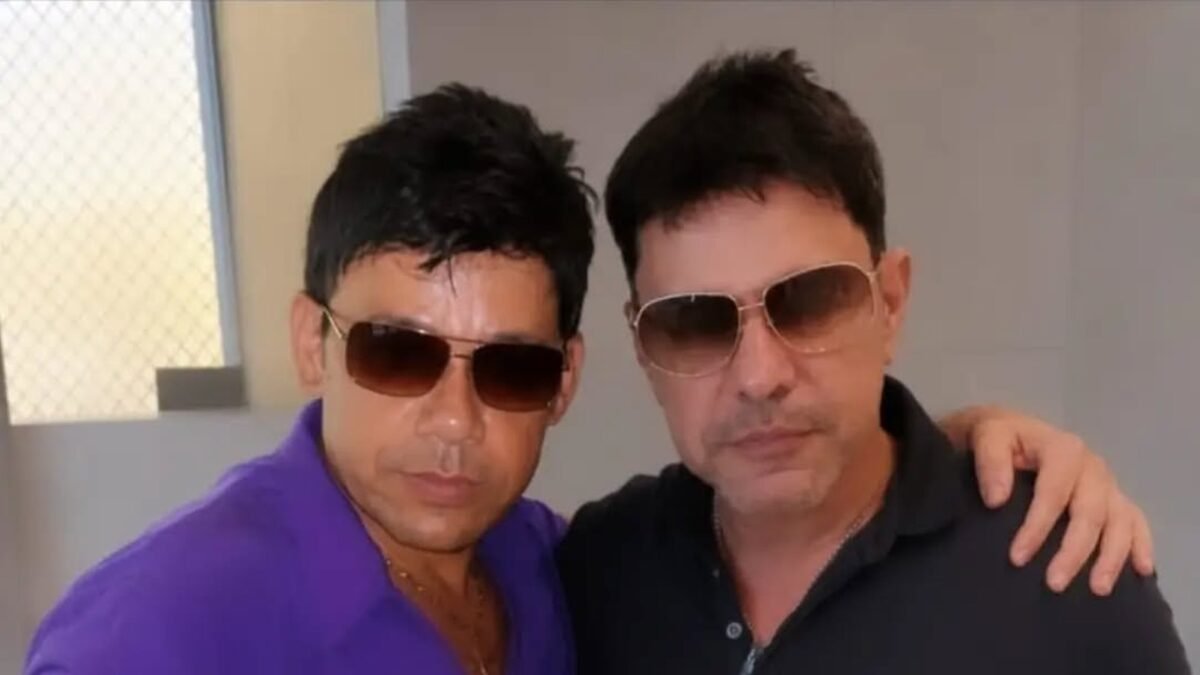 O sósia Zezé Mirosmeno, de camisa roxa, abraçado a Zezé Di Camargo, de camisa preta, os dois de óculos escuros