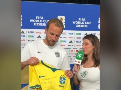 Victória Leite entrega a Harry Kane uma camisa amarela da Seleção Brasileira na zona de entrevistas da Copa do Mundo de 2026
