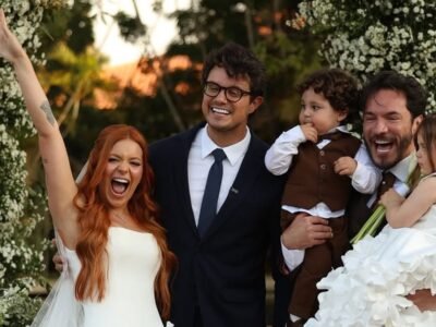 Viih Tube de vestido de noiva branco e Eliezer de terno, com os filhos Lua e Ravi, sob o arco de flores da cerimônia