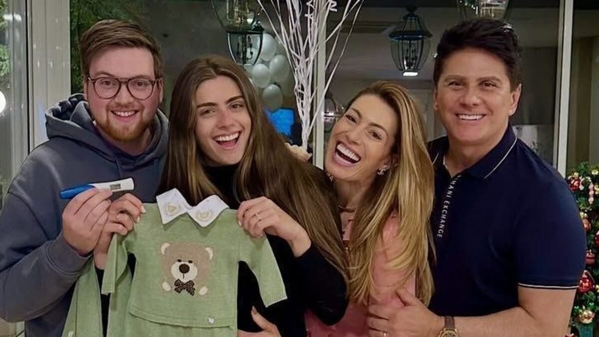 Ed Beccle, Luma Cesar, Elaine Mickely e César Filho seguram roupinha de bebê