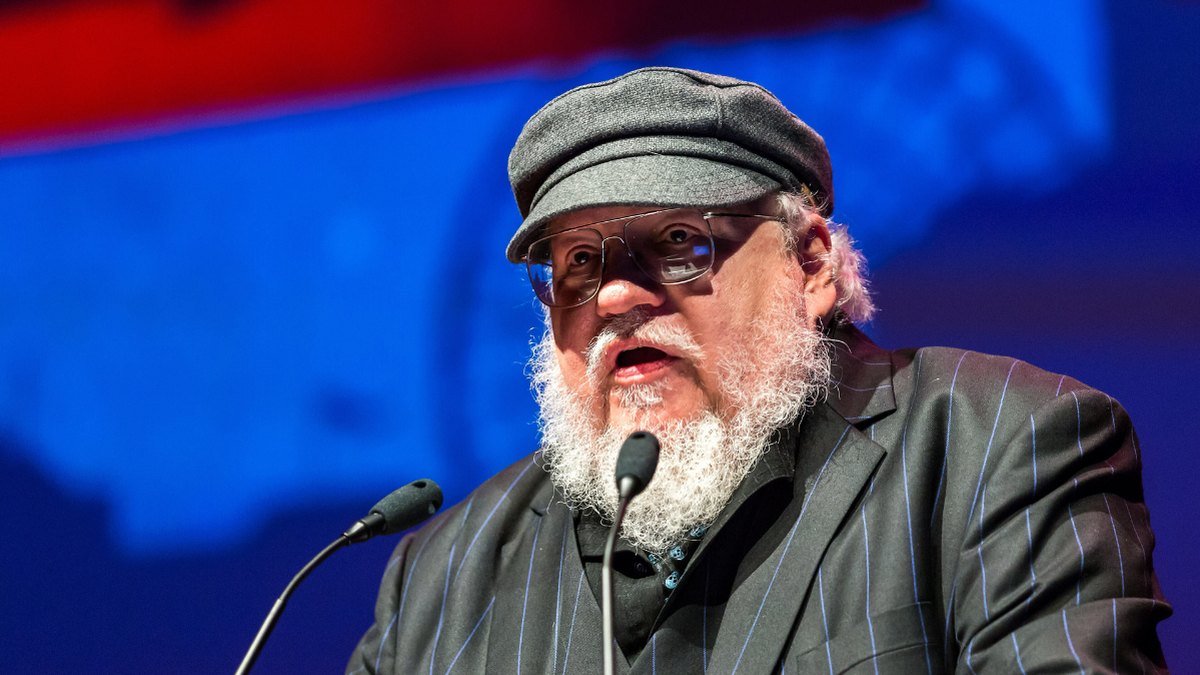 George R.R. Martin fala ao microfone num painel.