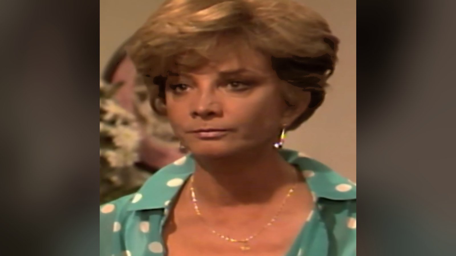 Gloria Menezes de blusa verde de bolinhas, em close de cena da novela Corpo a Corpo, de 1984