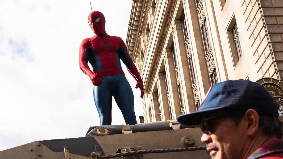 O herói em pé sobre um veículo militar numa rua de Nova York.