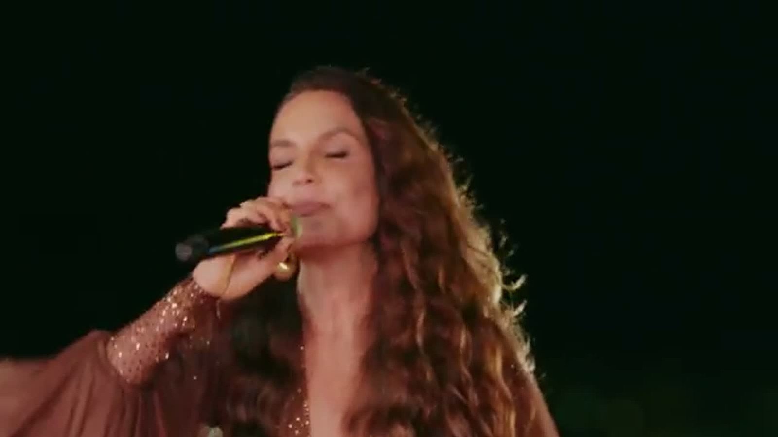 Close de Ivete Sangalo cantando Clareou de olhos semi-fechados
