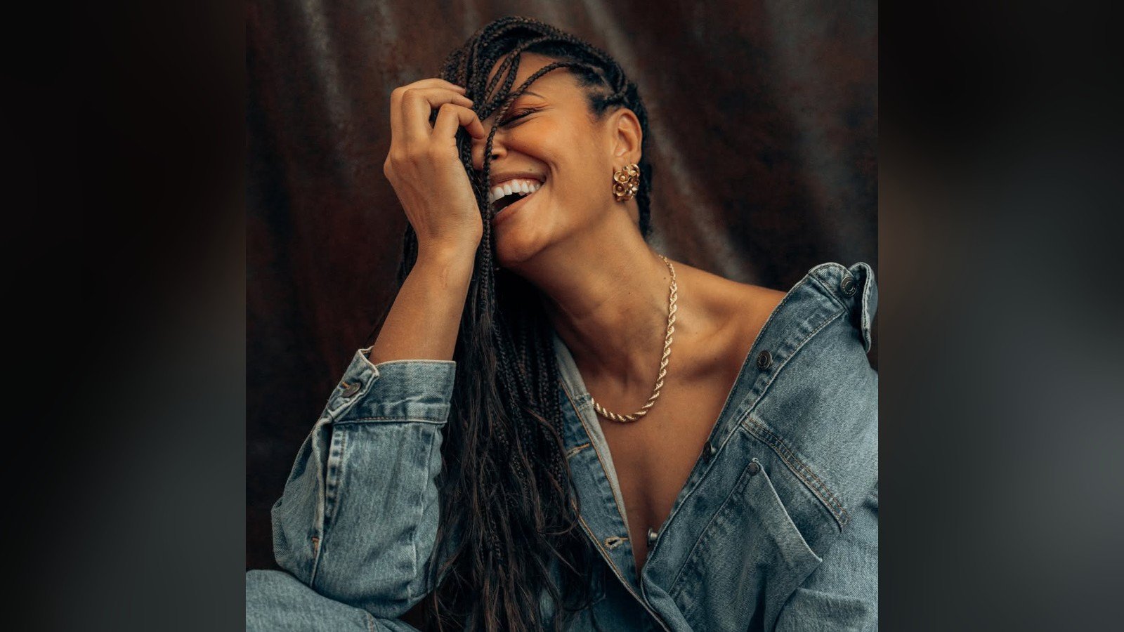 Sheron Menezzes rindo, de jaqueta jeans, em ensaio fotografico