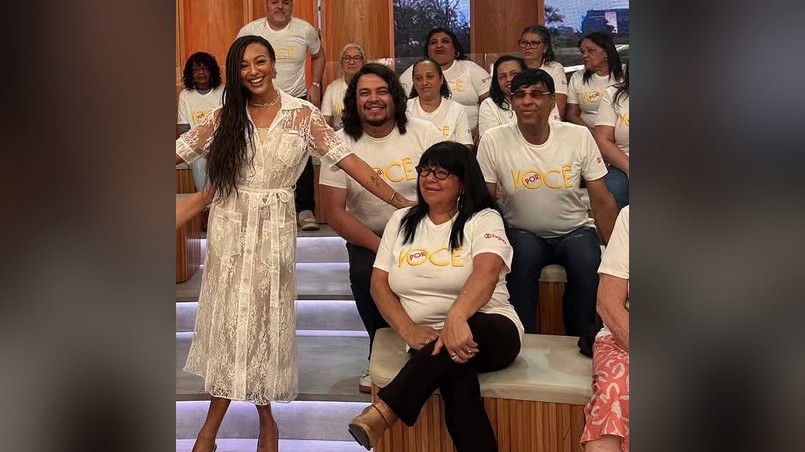 Sheron Menezzes de vestido branco em pe diante da plateia no estudio do programa Encontro