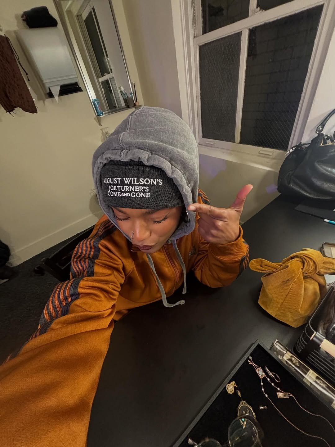 Maya Boyd de moletom com o nome da peca Joe Turner's Come and Gone, nos bastidores