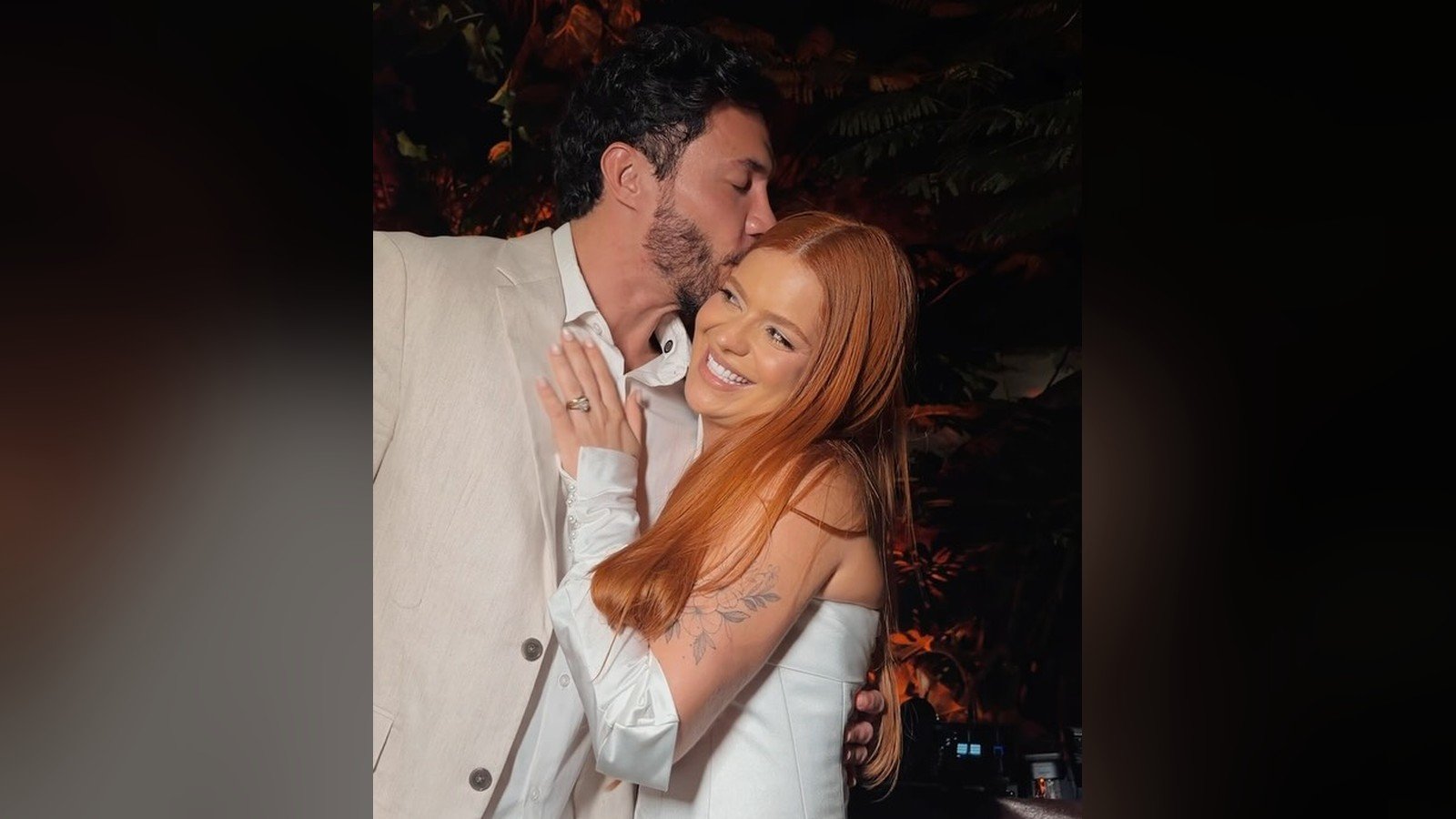 Viih Tube e Eliezer abracados, os dois de roupa clara, na noite do casamento civil