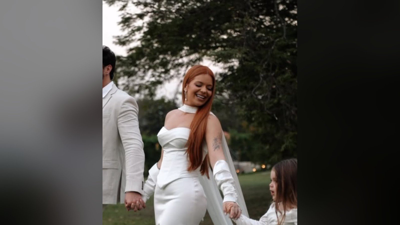 Viih Tube, Eliezer e os dois filhos de roupas brancas caminhando pelo gramado da fazenda