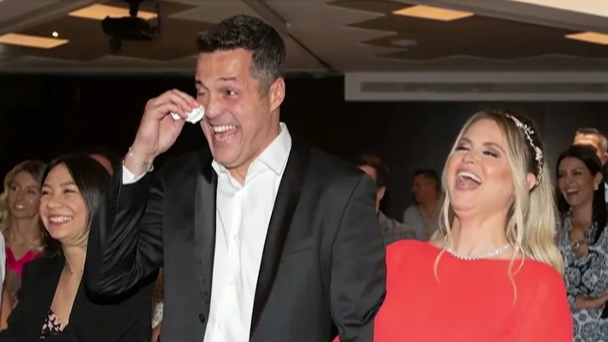 Júlio César, de terno preto, enxuga uma lágrima e ri ao lado de Susana Werner, de vestido vermelho, numa festa