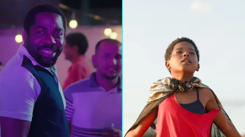 Lázaro Ramos sorri em cena de festa de Feito Pipa, ao lado de Yuri Gomes, o protagonista Gugu, com uma capa nos ombros