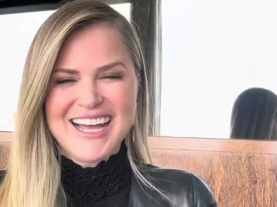 Susana Werner, de cabelo loiro e jaqueta de couro preta, rindo num restaurante em Lisboa
